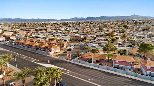 A view of a residential area with houses and palm trees.