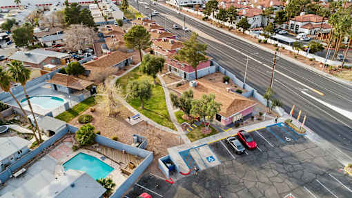 A parking lot with cars and a pool in the foreground.
