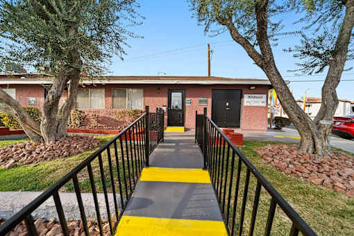 A building with a black fence and a yellow stripe on the ground.
