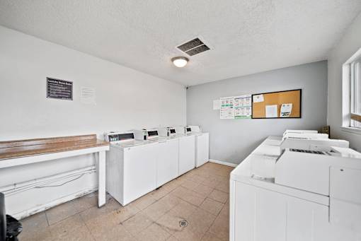 A room with white appliances and a brown bench.
