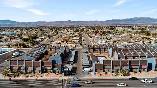 A large housing complex in a desert with mountains in the background.