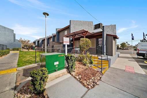 A modern building with a green dumpster in front of it.