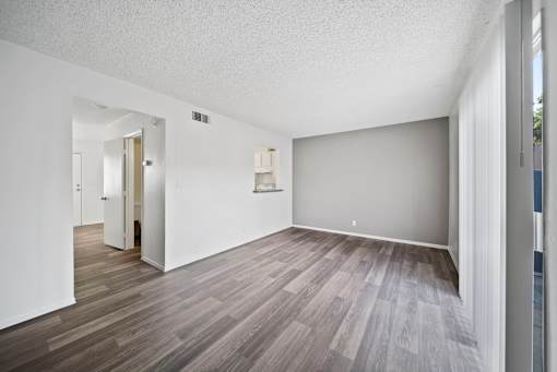 A room with wooden flooring and white walls.