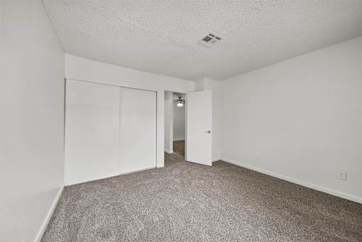 A room with a carpeted floor and white walls.