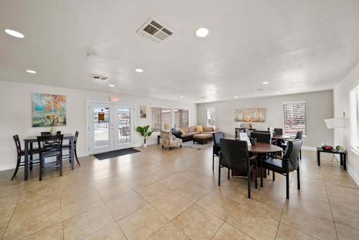 A spacious living room with a dining area and a kitchen in the background.