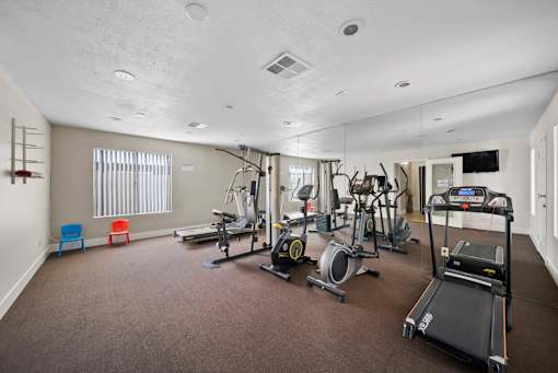 A spacious home gym with a variety of exercise equipment.