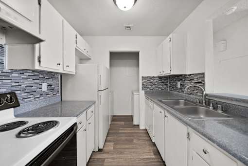 A kitchen with white cabinets and a stove top oven.