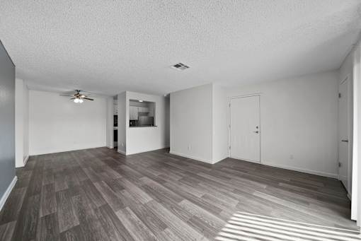 A room with a ceiling fan and a door.