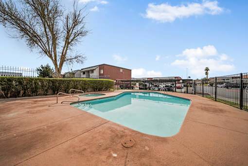 A small pool in a backyard with a fence around it.