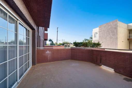 A patio with a red wall and a glass door.