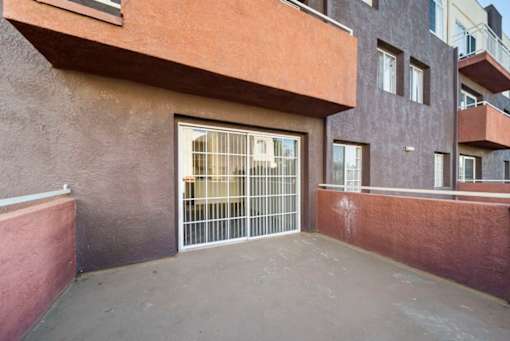 A building with a brown wall and a white gate.
