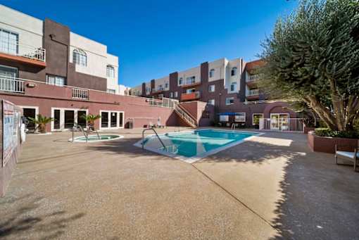 A large outdoor swimming pool surrounded by apartment buildings.