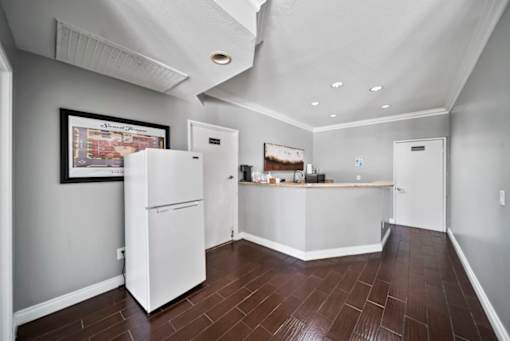 A kitchen with white appliances and wood floors.