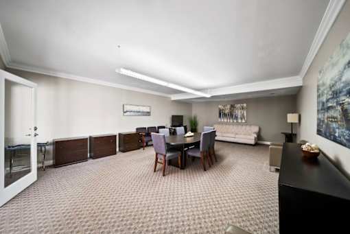 A living room with a grey carpet and a black piano.