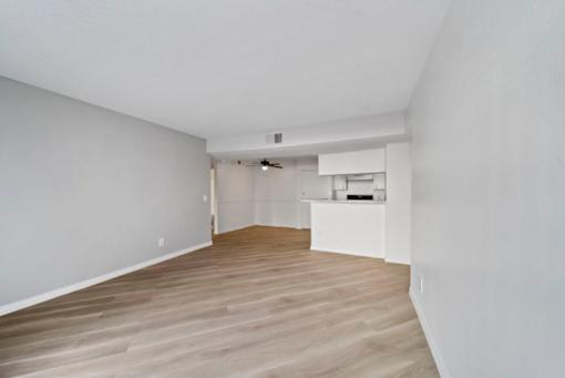 A room with wooden flooring and white walls.