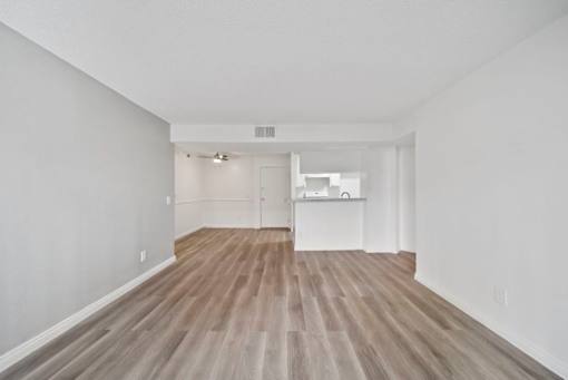 A room with wooden flooring and white walls.
