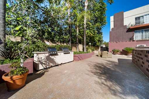 A courtyard with a concrete floor and a wall with a window.