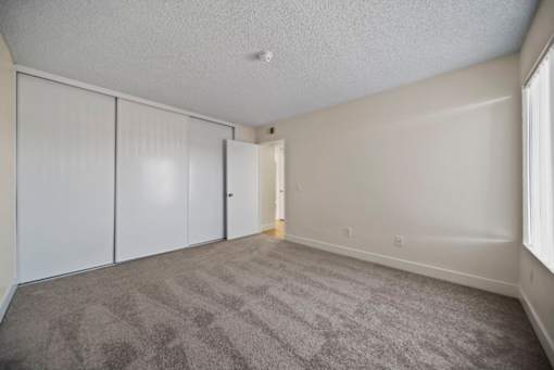 A room with grey carpet and white walls.