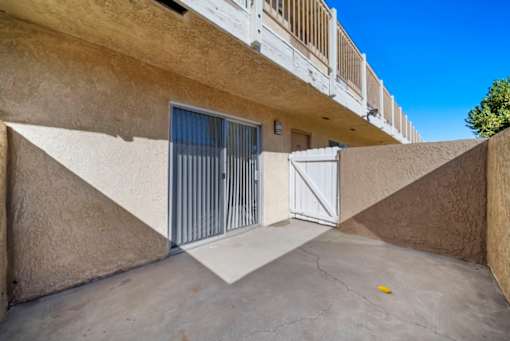 A concrete building with a white gate and a yellow object on the ground.