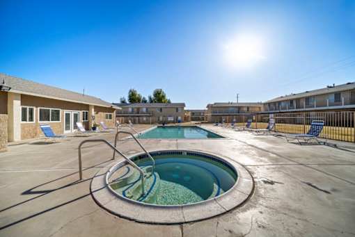 A sunny day at the outdoor pool with a hot tub.