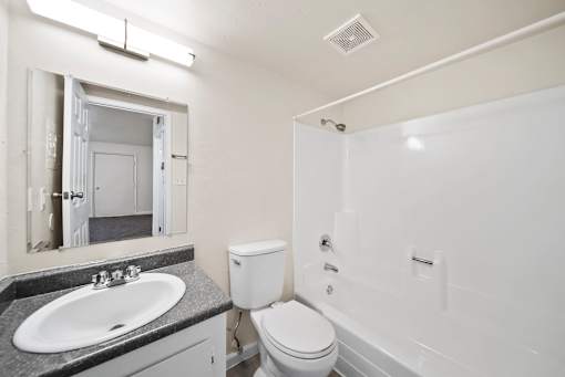 A bathroom with a toilet, sink, and bathtub.