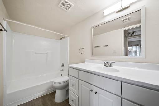A white bathroom with a toilet, sink, and bathtub.