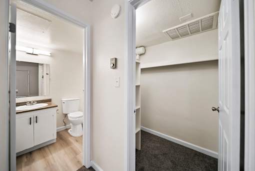 A bathroom with a toilet, sink, and mirror.