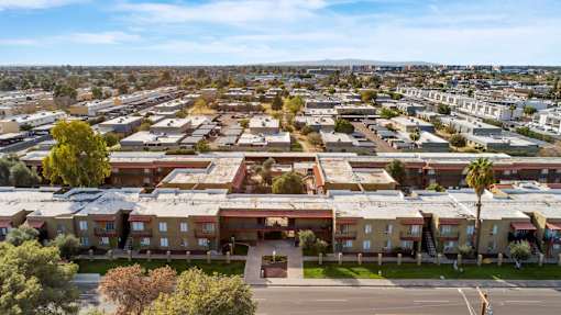 A large apartment complex with a parking lot in front.