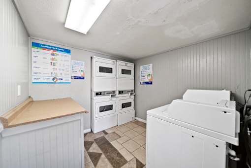 A small kitchen with white appliances and a wooden counter.