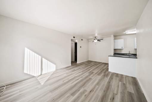 A room with wooden flooring and a ceiling fan.