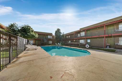 A pool in a courtyard surrounded by a fence.