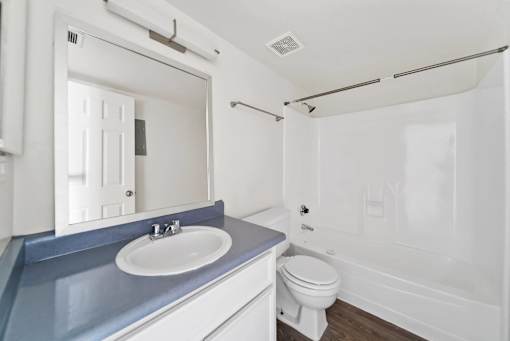 A white bathroom with a blue counter top.