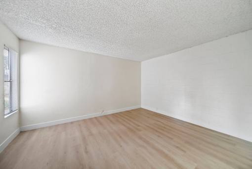 A room with wooden flooring and white walls.