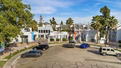 A parking lot with cars and a building in the background.