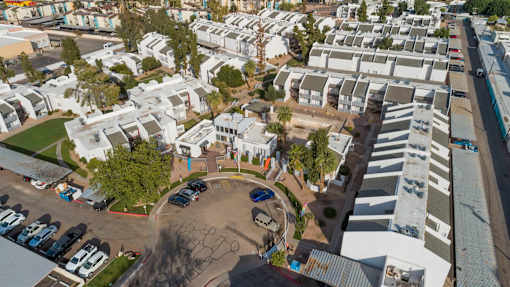 A parking lot with cars and a building in the background.
