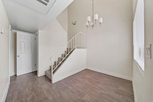 A room with a staircase and a chandelier.