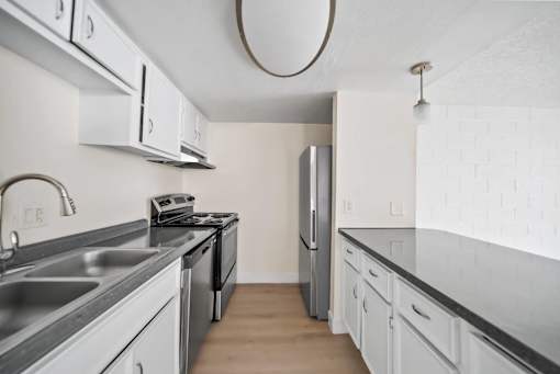 A kitchen with a stove top oven and a refrigerator.