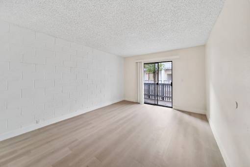 A room with a white brick wall and wooden floor.