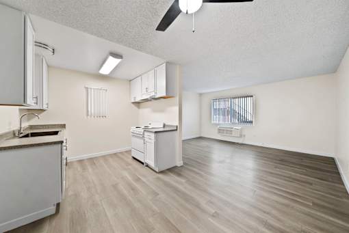 A kitchen with a white fridge, dishwasher, and cabinets.