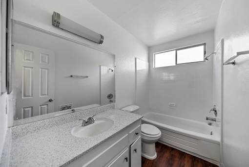 A white bathroom with a sink, toilet, and bathtub.
