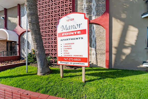 A sign for the Maror Apartments is displayed in front of a building.