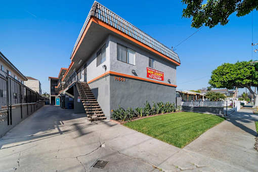A modern house with a grey and orange exterior and a blue door.