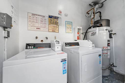 A white industrial machine sits in a room with a white wall and a sign that says "OPERATION INSTRUCTIONS" on the wall.
