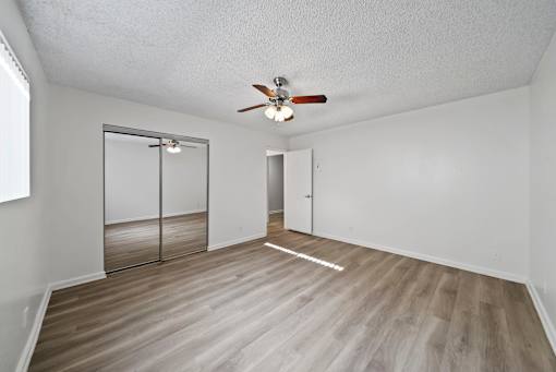A room with a ceiling fan and a sliding door.