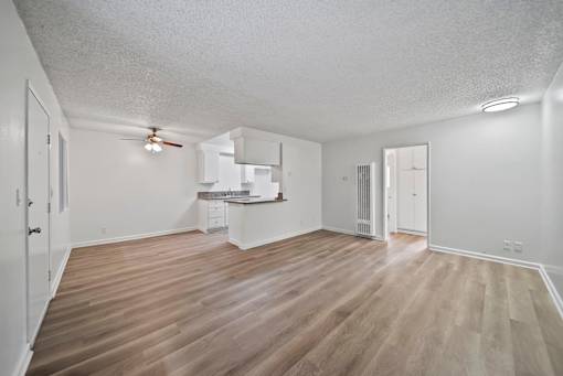 A room with wooden flooring and white walls.