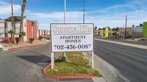 A sign for Sonoma Hills Apartment Homes stands in front of a street.