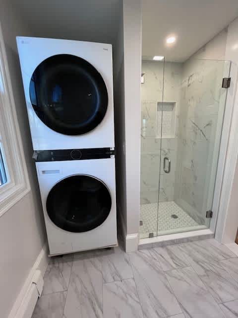 A white front loading washing machine in a bathroom.