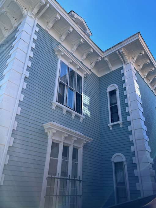 A building with a blue siding and white trim.