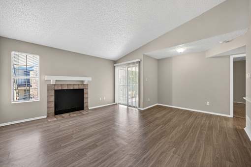 A living room with a fireplace and sliding glass doors at Logans Mill, Austin, TX.