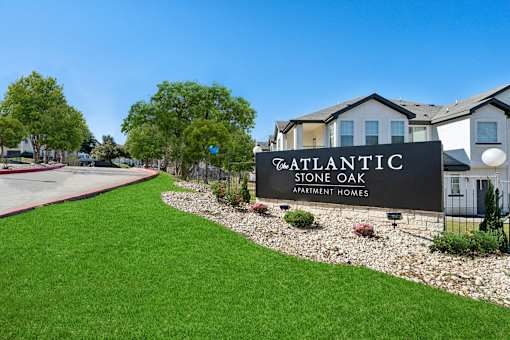 A sign for Atlantic Stone Oak Apartment Homes is in front of an apartment building at The Atlantic Stone Oak Apartments, San Antonio